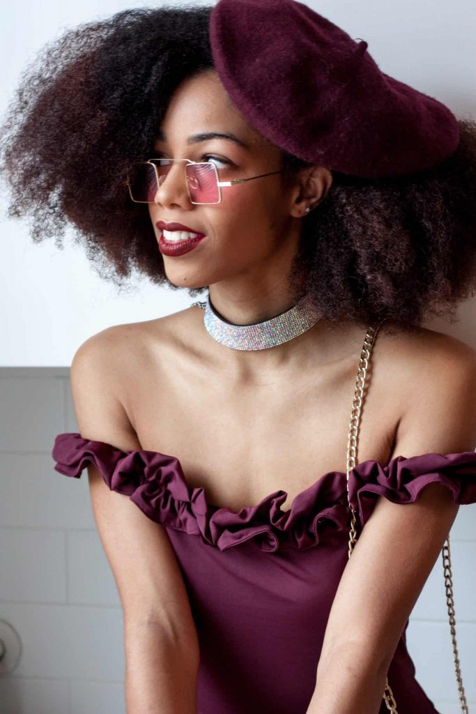 Black woman with Natural Hair Afro weating a purple Beret with Sparkly choker