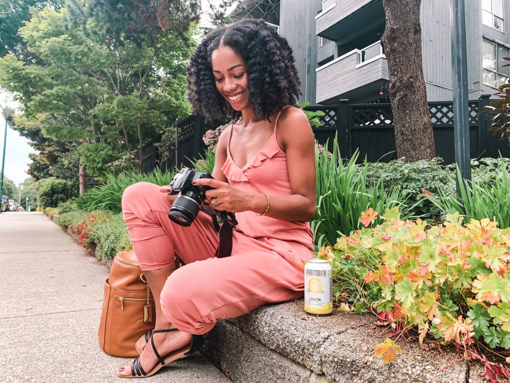 Black Canadian Blogger, Comfy Girl with Curls reviewing photos on camera. SPARKMOUTH Sparkling Water in lemon. #FindYourSpark