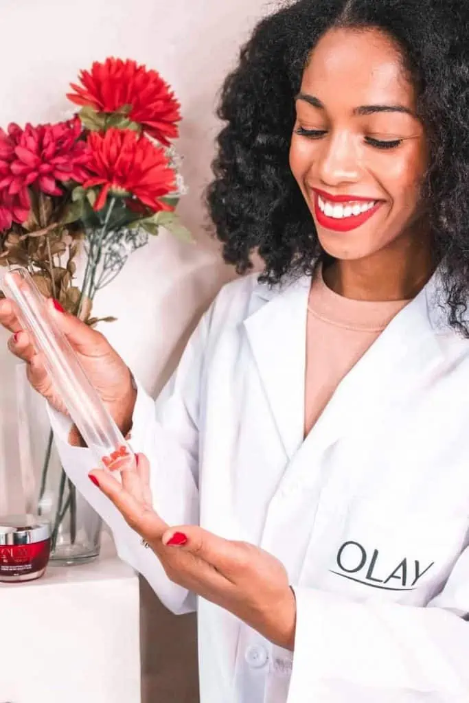 Black Blogger Holding Test Tube for Olay Regenerist Multi-Sculpting Cream Review
