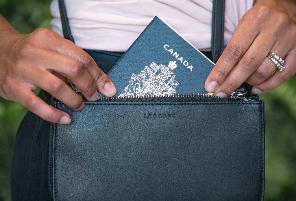 Best convertible bag for Travel: Lo & Sons Waverley 2 in black pictured with a Canadian passport.