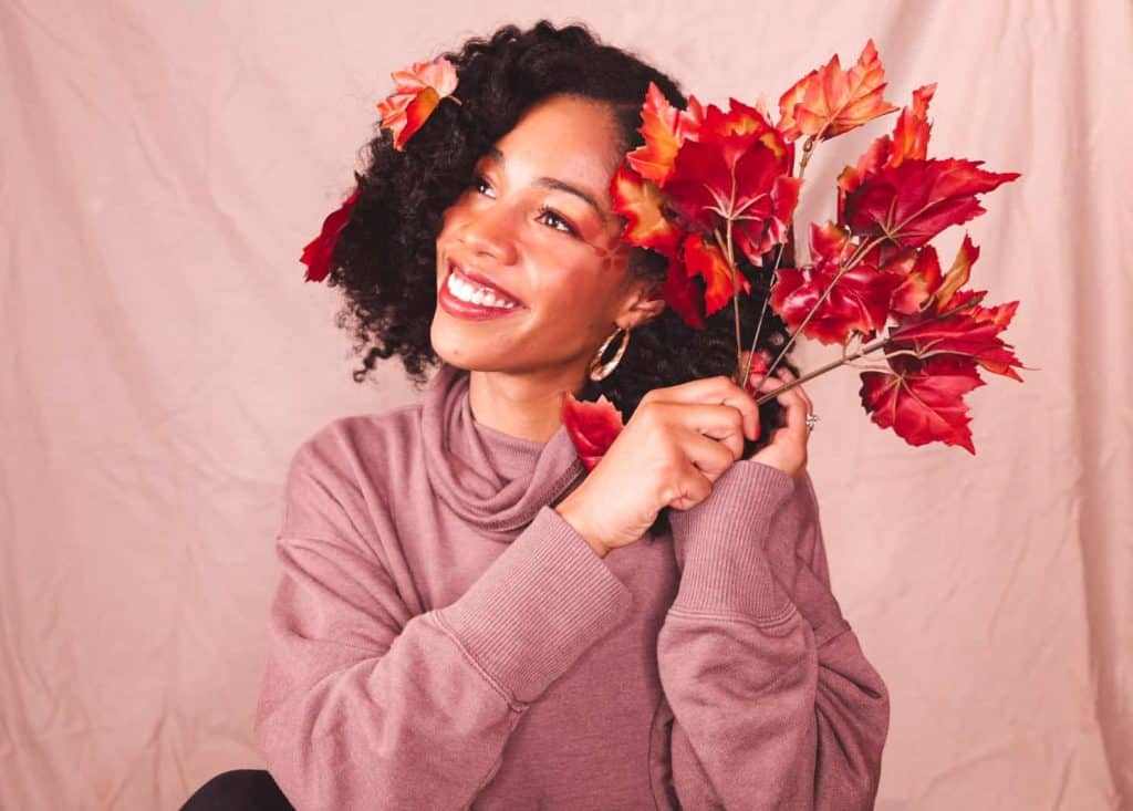 Black girl with Natural Hair Dressed up as an autumn tree for Halloween looking in the distance